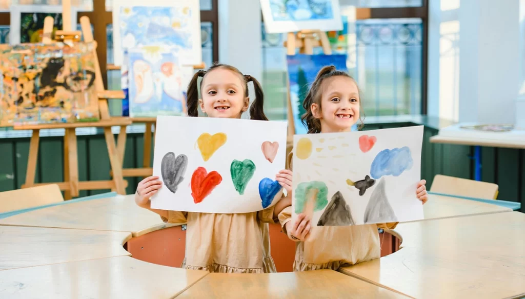 Children holding heart drawings